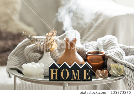 Aroma composition with a modern aroma oil diffuser, candles and a knitted element. 135873870