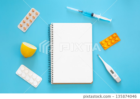 Blank notepad, medicines, pills and thermometer on a blue background, flat lay. 135874046