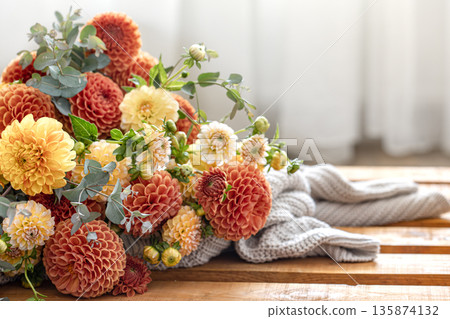 A bouquet of yellow and orange chrysanthemums on a blurred background. A bouquet of yellow and orange chrysanthemums on a blurred background. 135874132