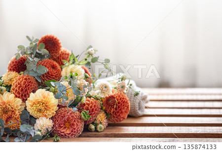 A bouquet of yellow and orange chrysanthemums on a blurred background. 135874133
