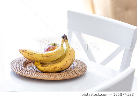 A bunch of ripe bananas in a bright kitchen interior. A bunch of ripe bananas in a bright kitchen interior. 135874188