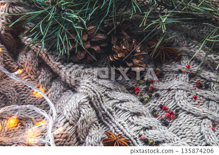 Christmas background with cones and spices on a knitted element. Christmas background with cones and spices on a knitted element. 135874206