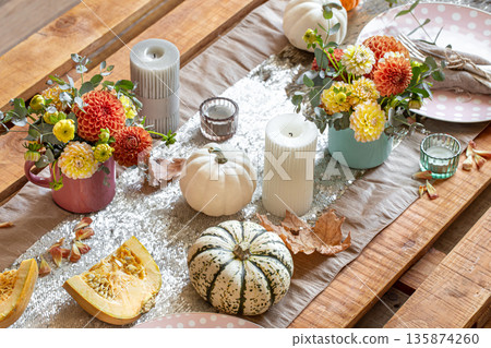 Festive table setting with pumpkins, candles and chrysanthemum flowers. 135874260