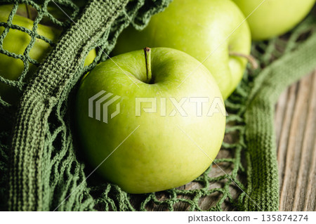 Close-up, green apples in a mesh shopping bag. 135874274