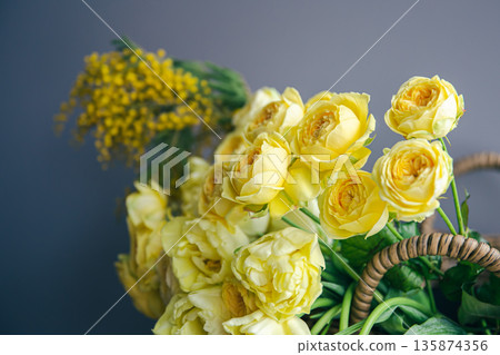 Close-up of yellow spring flowers in a basket. Close-up of yellow spring flowers in a basket. 135874356