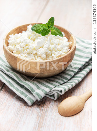 Cottage cheese in wooden bowl with mint leaf Cottage cheese in wooden bowl with mint leaf 135874566