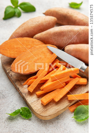 Sweet potato sticks with knife on wooden board 135874575