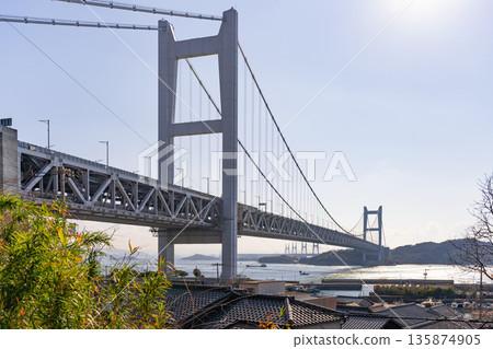 Kurashiki City, Okayama Prefecture: The Seto Ohashi Bridge and the Tanoura townscape as seen from Tadoura Shrine Kurashiki City, Okayama Prefecture: The Seto Ohashi Bridge and the Tanoura townscape as seen from Tadoura Shrine 135874905