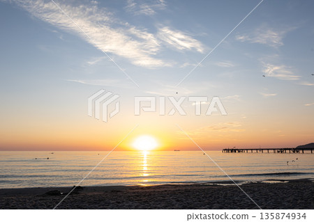 Sea embankment at sunset with a clear cloudless sky. 135874934