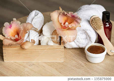 Spa composition with body care products in a wooden box and Thai orchid flowers. Spa composition with body care products in a wooden box and Thai orchid flowers. 135875000