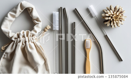 Eco-friendly stainless steel straws, cleaning brushes, and bamboo toothbrush arranged neatly on a light background, promoting sustainable living and reducing plastic waste Eco-friendly stainless steel straws, cleaning brushes, and bamboo toothbrush arranged neatly on a light background, promoting sustainable living and reducing plastic waste 135875084