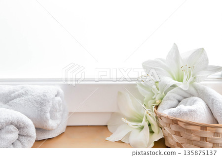 Spa composition with lily flowers and towels in a basket. Spa composition with lily flowers and towels in a basket. 135875137