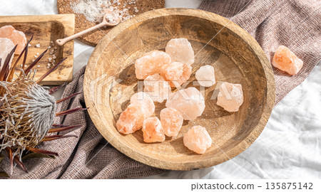 Spa composition with pieces of sea salt in a wooden plate. 135875142