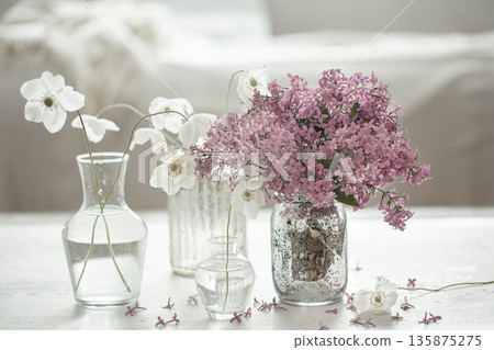 Close-up of bouquets of spring flowers in vases on a blurred background. Close-up of bouquets of spring flowers in vases on a blurred background. 135875275