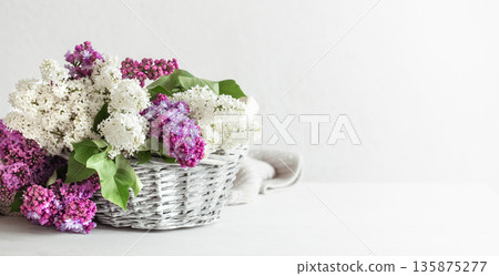 Spring composition with lilac flowers in a wicker basket. 135875277