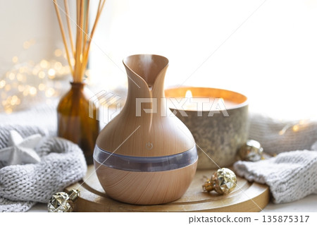 Still life with an aroma diffuser for moisturizing the air and winter decor. Still life with an aroma diffuser for moisturizing the air and winter decor. 135875317