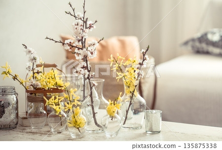 Still life with vases with spring flowers in the living room 135875338