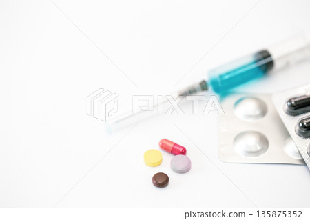 Syringe and pills on a white background isolated, close-up. 135875352