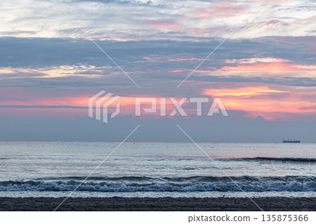 Texture sea waves at sunset with pink clouds. Texture sea waves at sunset with pink clouds. 135875366
