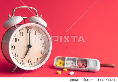 Time for health check concept. White alarm clock with pills. Time for health check concept. White alarm clock with pills. 135875384
