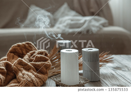 Extinguished candles are smoking on the table in the interior of the room. Extinguished candles are smoking on the table in the interior of the room. 135875533