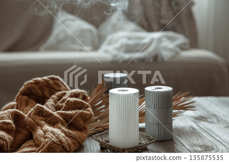 Extinguished candles are smoking on the table in the interior of the room. 135875535