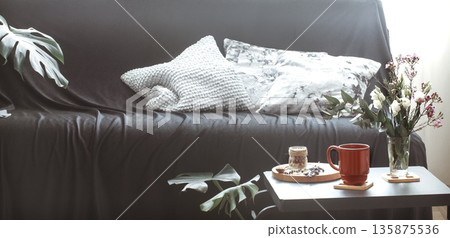 Cozy home interior living room with a black sofa and a vase of flowers Cozy home interior living room with a black sofa and a vase of flowers 135875536