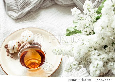 Cozy spring composition with tea and blooming lilac. Cozy spring composition with tea and blooming lilac. 135875538