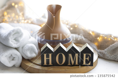 Cozy winter composition with essential oil aroma diffuser and wooden word Home. 135875542