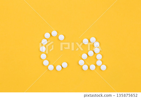 Flat lay composition with calcium supplement pills on yellow background. 135875652