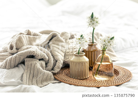 Home composition with flowers in vases and a knitted element. 135875790