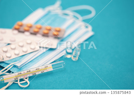Medical background with thermometer, pills and masks close-up. 135875843