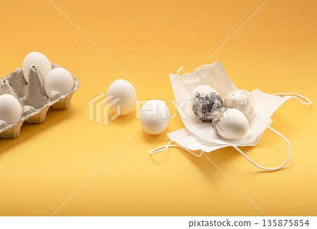 Easter composition with Easter eggs in protective medical masks. 135875854