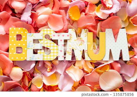 Best Mum written in multicolored wooden letters on bright background of fresh rose petals. 135875856