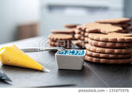 Pastry bags with cream for decorating gingerbread. 135875976
