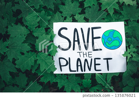 Poster with the inscription save the planet in the forest among the plants. Poster with the inscription save the planet in the forest among the plants. 135876021