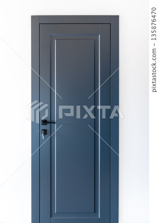 Blue interior door with key in lock on white wall. Minimal entry. 135876470