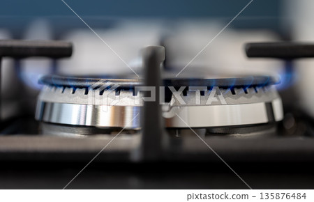 Close-up gas burner. Blue flame. Stylish kitchen macro. Close-up gas burner. Blue flame. Stylish kitchen macro. 135876484