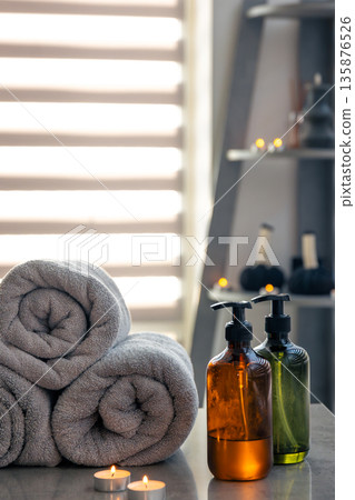 Glass dispensers and gray towels with candles. Spa aesthetic 135876526