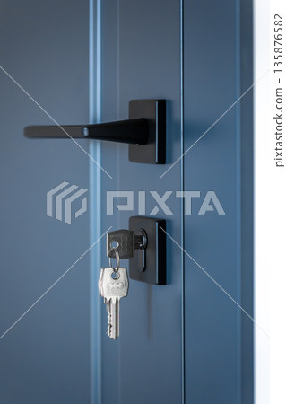 Modern door handle. Keys in cylinder. Blue interior door. Modern door handle. Keys in cylinder. Blue interior door. 135876582