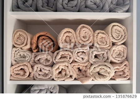 Rolled spa towels on shelf in soft neutrals. Spa towels. Rolled spa towels on shelf in soft neutrals. Spa towels. 135876629