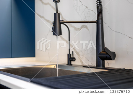 Title: Black faucet. Water stream. Blue kitchen 135876710