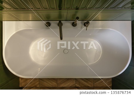 White bathtub top view amid green tiles. Top view. 135876734