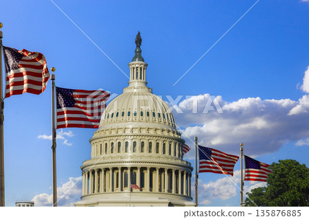 American flags fly next to Capitol building in Washington D.C. on sunny day with blue skies, clouds above. American flags fly next to Capitol building in Washington D.C. on sunny day with blue skies, clouds above. 135876885