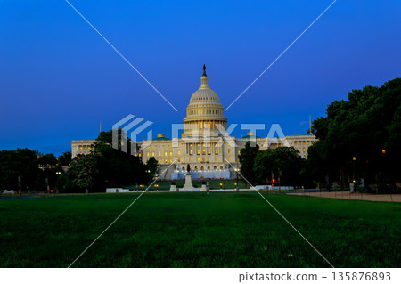 People stroll on grass near US Capitol building as lights shine in early evening sky in Washington DC People stroll on grass near US Capitol building as lights shine in early evening sky in Washington DC 135876893