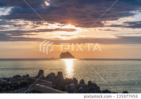Silhouette of a Ship Passing Keelung Islet at Sunrise in Taiwan. Silhouette of a Ship Passing Keelung Islet at Sunrise in Taiwan. 135877458