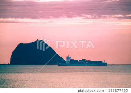 Silhouette of a Ship Passing Keelung Islet at Sunrise in Taiwan. Silhouette of a Ship Passing Keelung Islet at Sunrise in Taiwan. 135877465