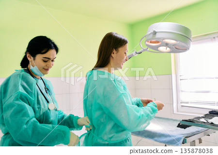 Medical Team Assists Patient In Bright Operating Room During Surgery Medical Team Assists Patient In Bright Operating Room During Surgery 135878038