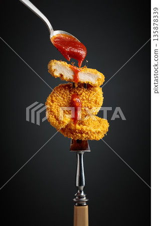 Nuggets with tomato sauce. 135878339