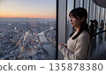 一名女子正在高樓的觀景台上欣賞風景。 135878380